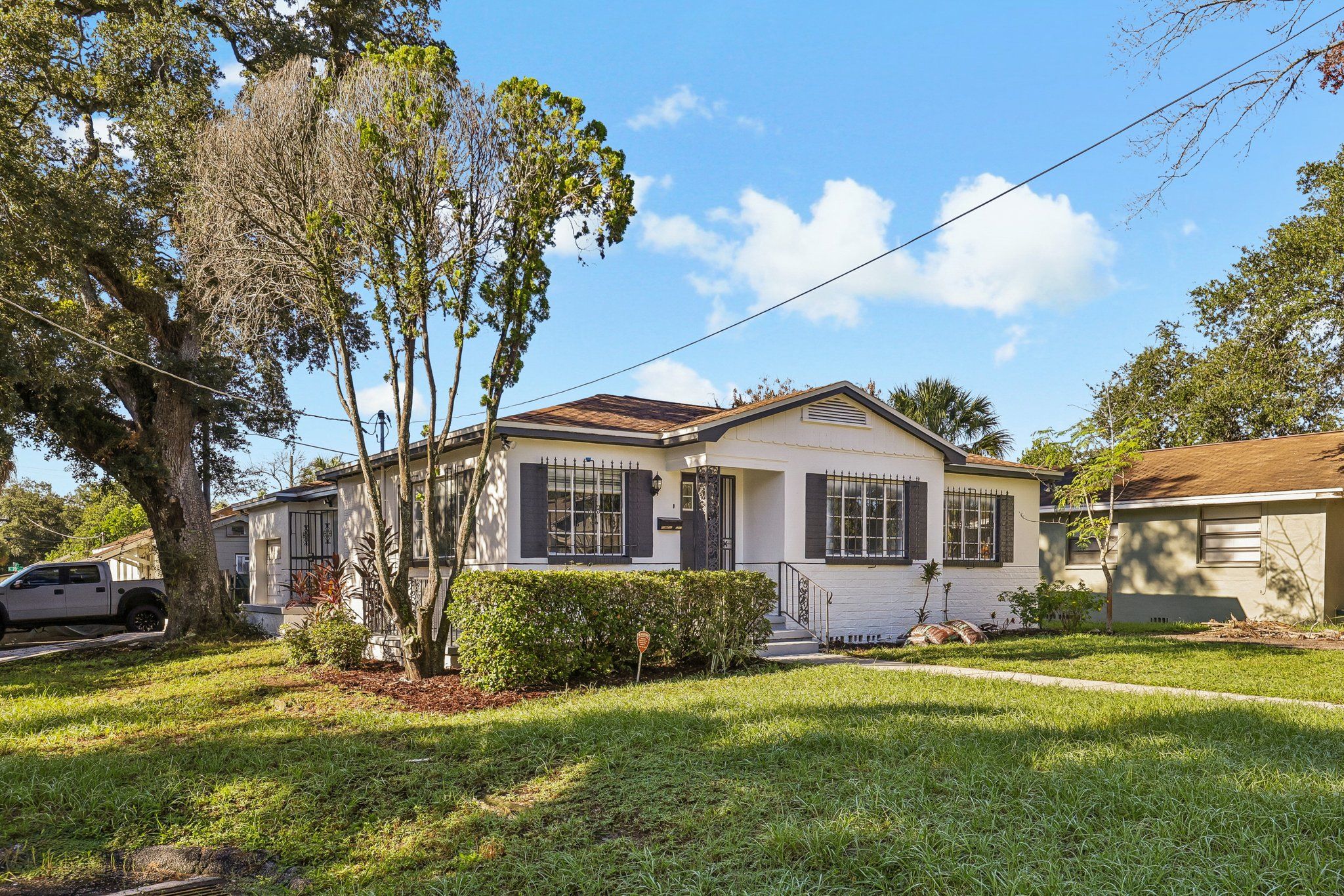 Front of a renovated Tampa home with fresh paint and dark shutters