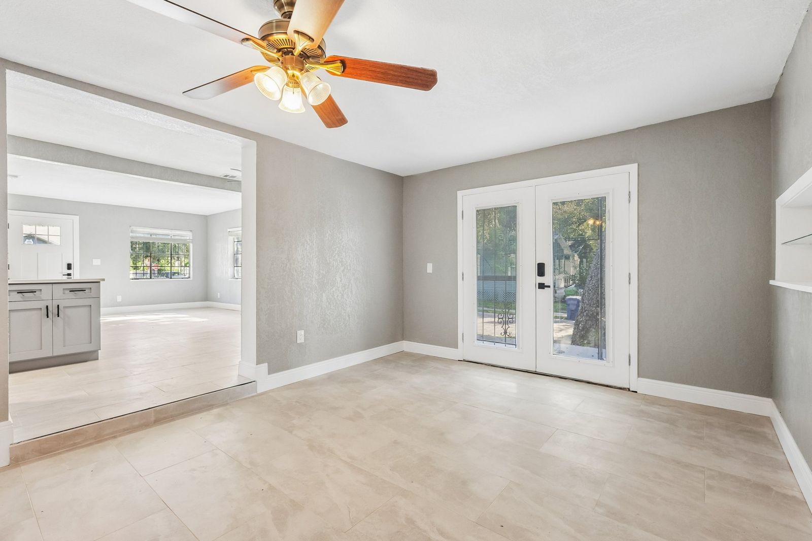 Open living area with new tile floors and French doors after a whole-home renovation